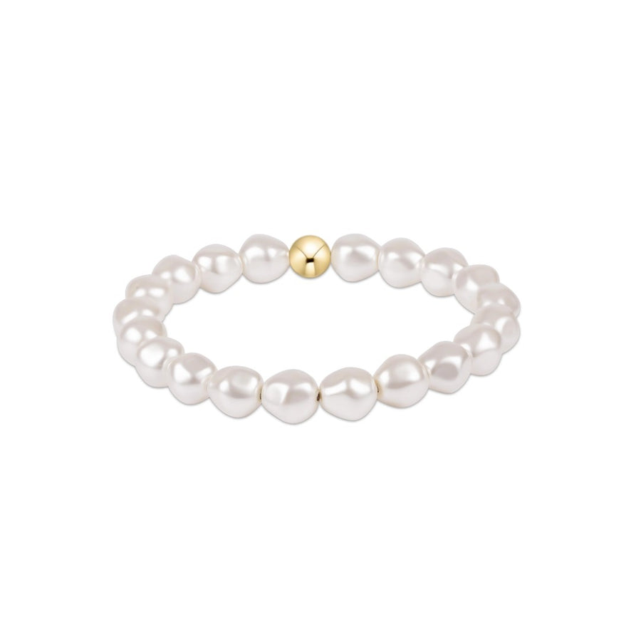 A beaded stretch bracelet featuring irregular white freshwater pearls and a single polished gold accent bead at the center, shown on a plain white background.
