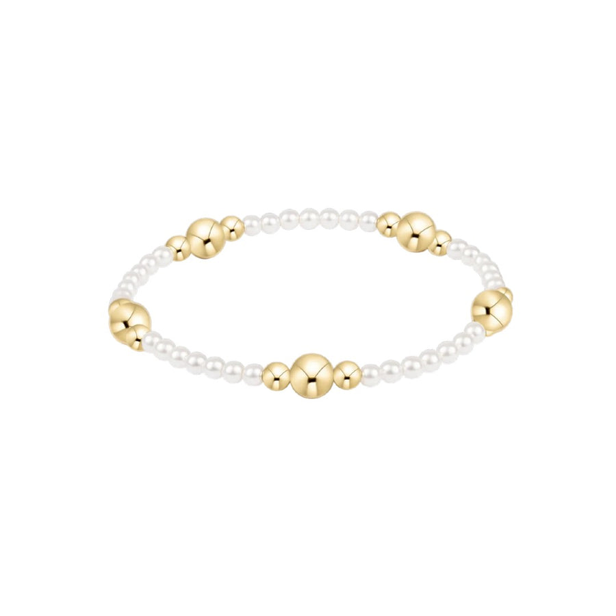 A delicate beaded bracelet featuring small white pearl-like beads and polished gold-toned spacer beads, displayed on a clean white background.