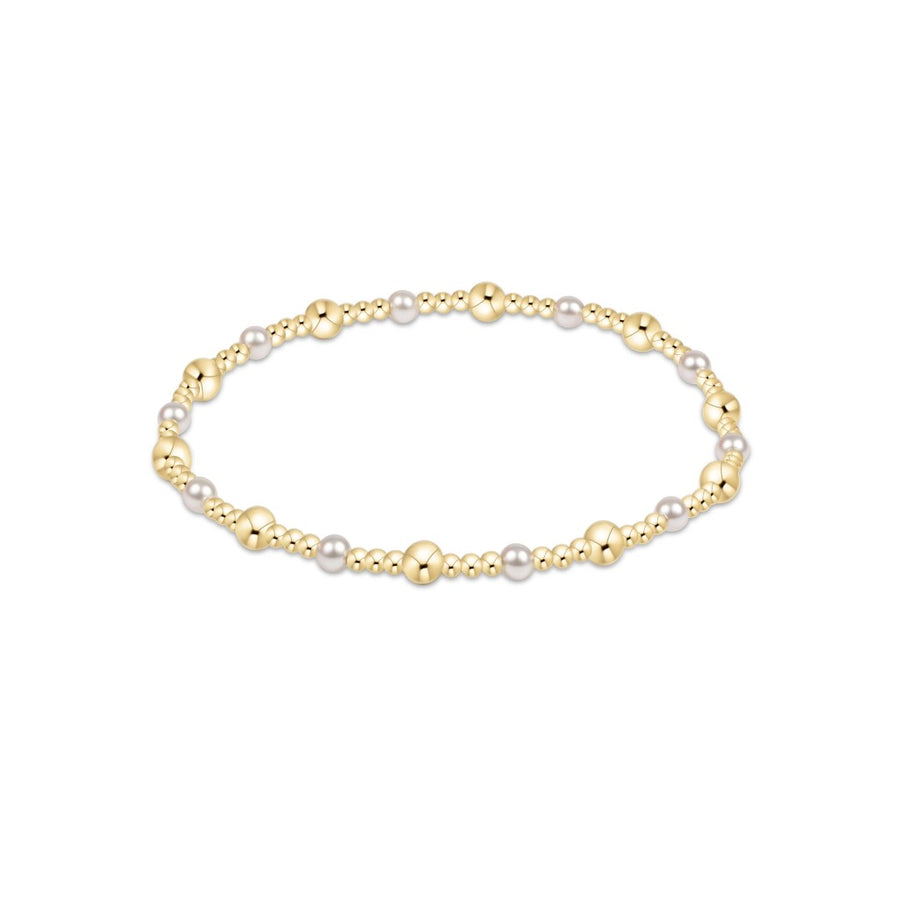 A delicate beaded bracelet featuring alternating polished gold beads and small white pearls, displayed on a clean white background.