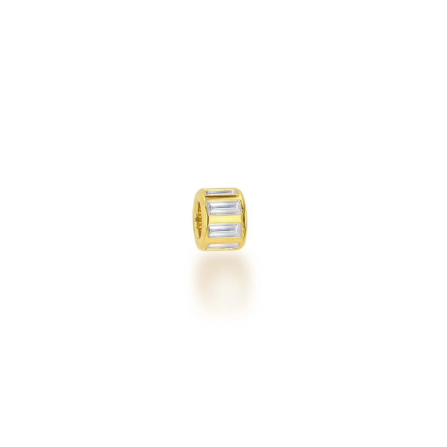 A gold cylindrical charm bead featuring three baguette-cut clear crystals, shown on a clean white background with a soft reflection.