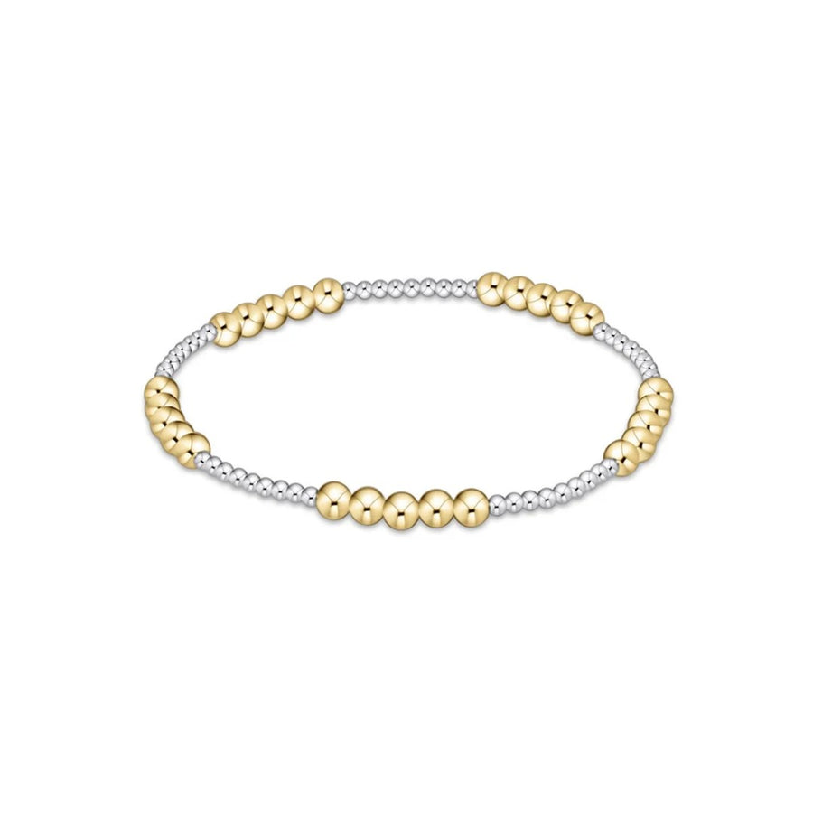 A two-tone beaded stretch bracelet featuring polished yellow gold round beads alternating with small silver-toned metallic beads, shown on a plain white background.