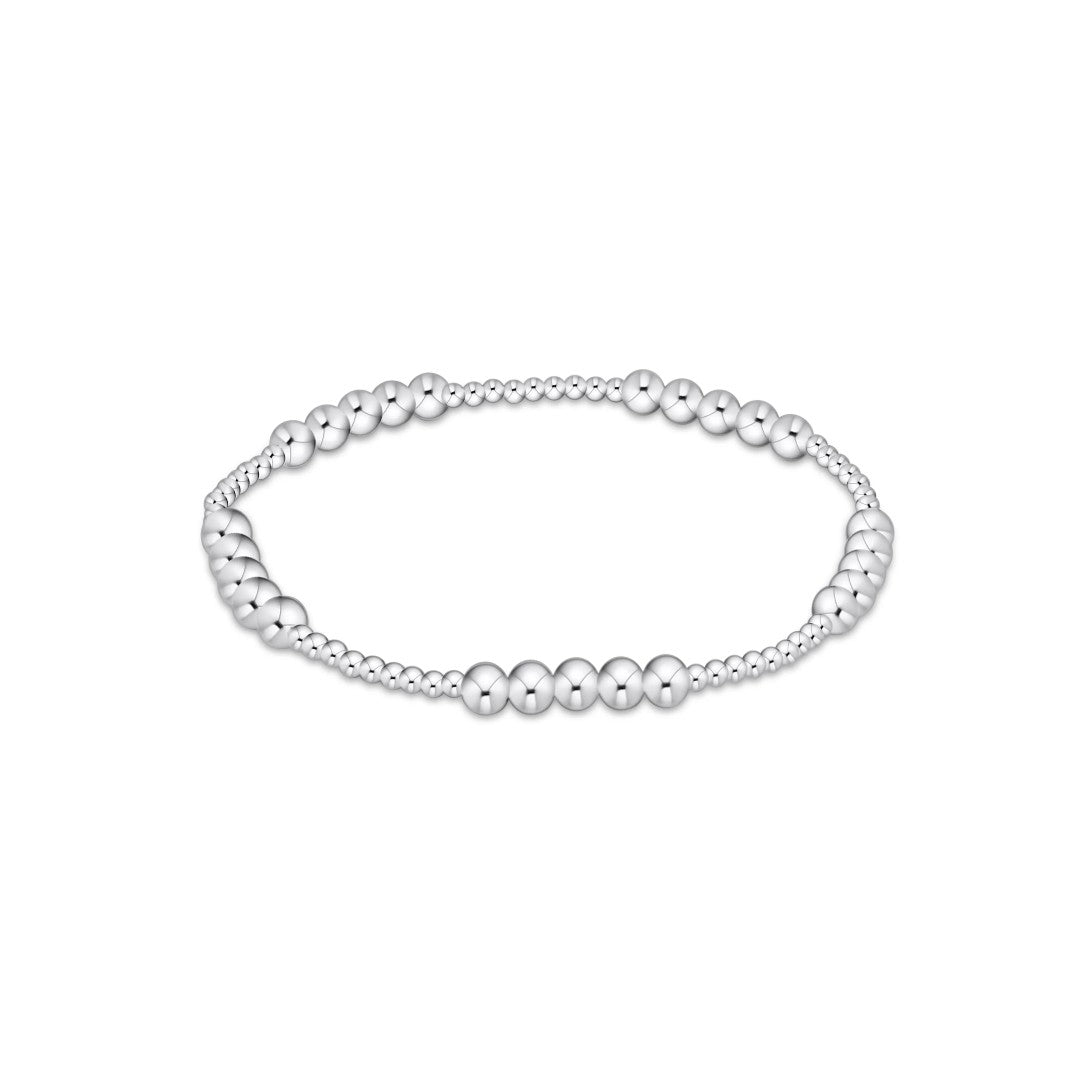 A silver beaded stretch bracelet featuring alternating smooth and textured round beads, displayed against a solid white background.