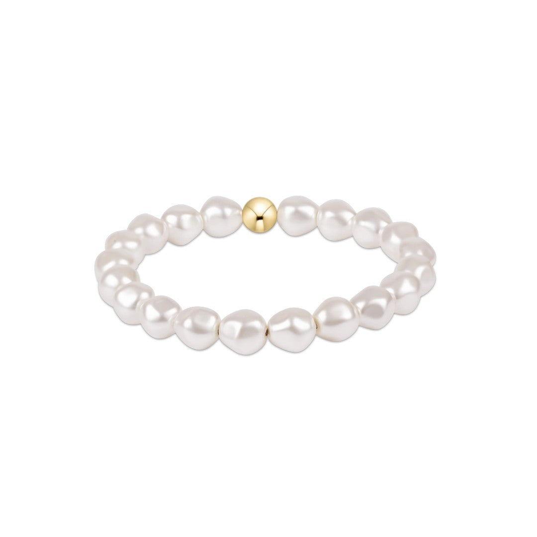 A beaded stretch bracelet featuring irregular white freshwater pearls and a single polished gold accent bead at the center, shown on a plain white background.