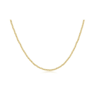 A delicate yellow gold chain necklace displayed in a U-shape against a solid white background.