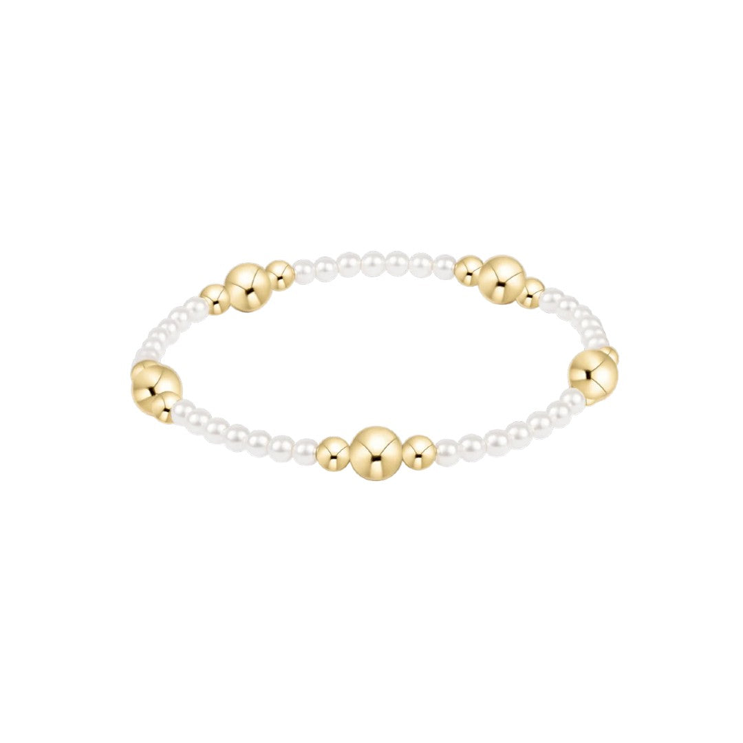 A delicate beaded bracelet featuring small white pearl-like beads and polished gold-toned spacer beads, displayed on a clean white background.