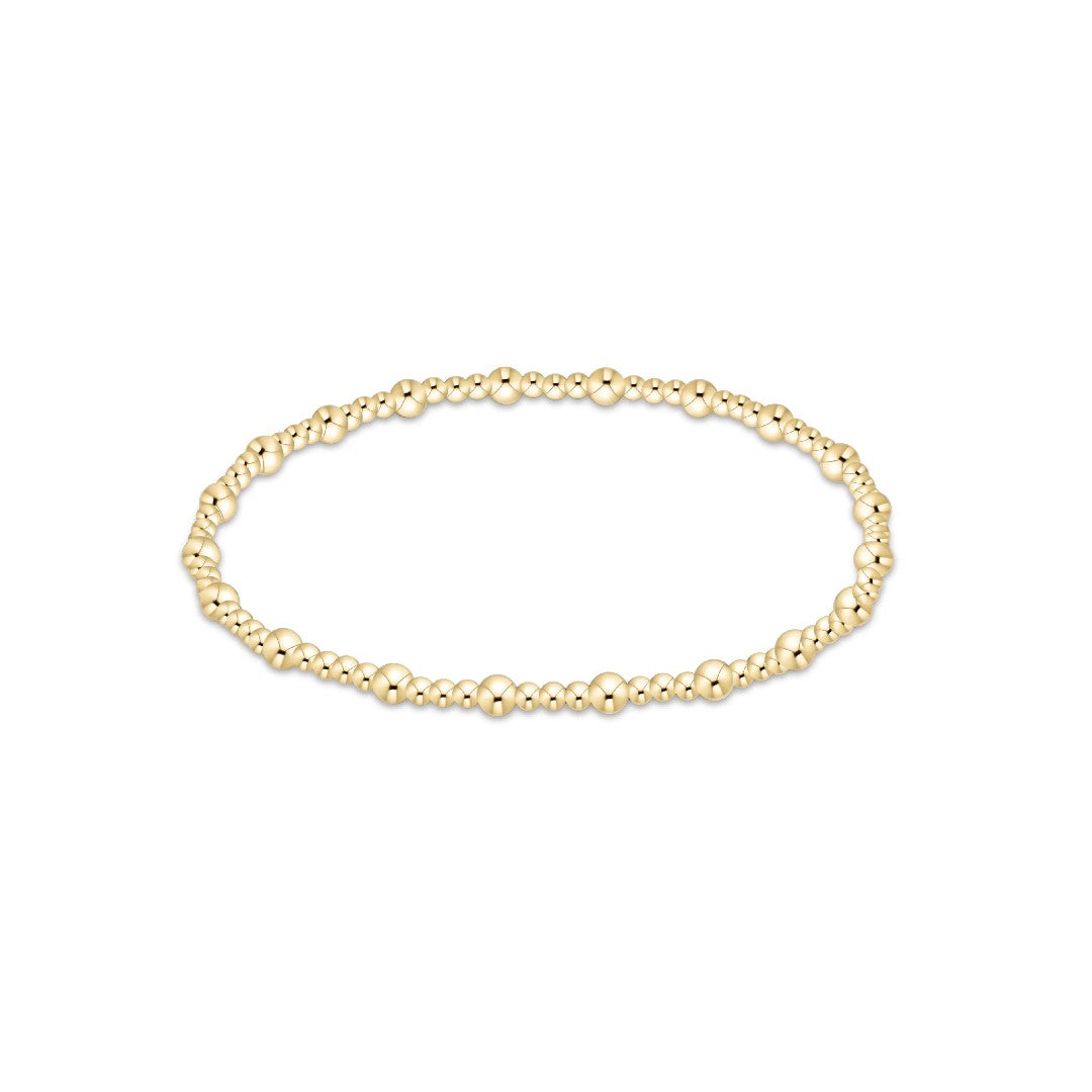 A delicate gold beaded bracelet with small, polished spherical beads linked together in a circular shape, displayed on a clean white background.
