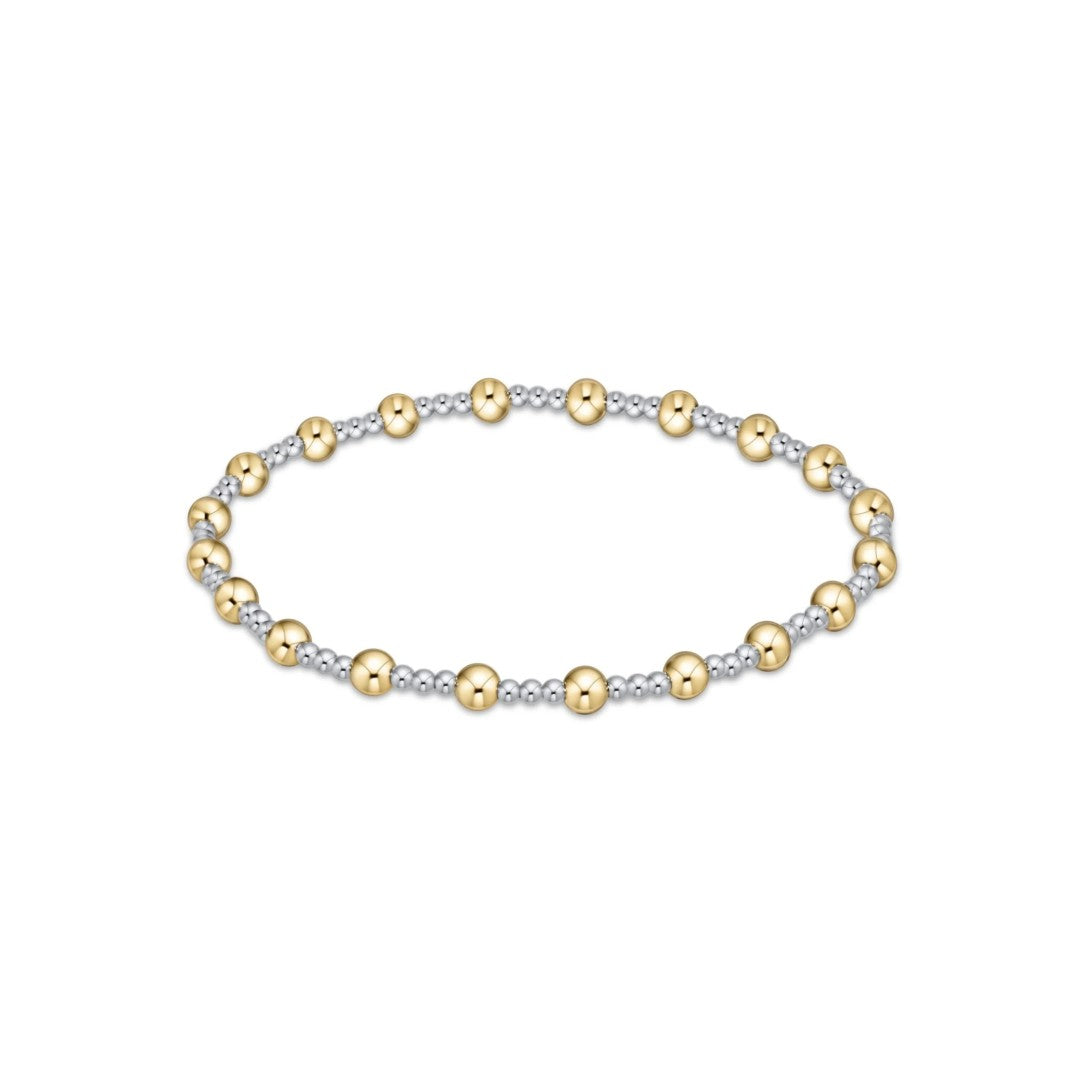 A delicate beaded stretch bracelet featuring alternating polished yellow gold beads and textured silver-tone beads, displayed on a clean white background.
