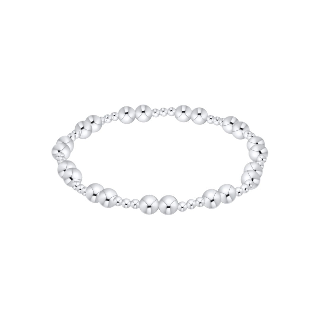 A silver beaded stretch bracelet featuring alternating larger round beads and smaller smooth beads, displayed on a clean white background.