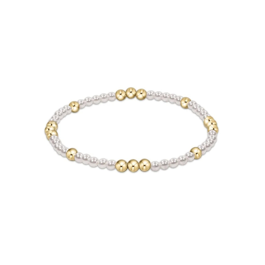 A delicate beaded stretch bracelet featuring small white pearl-like beads alternating with polished gold metallic beads, shown on a plain white background.
