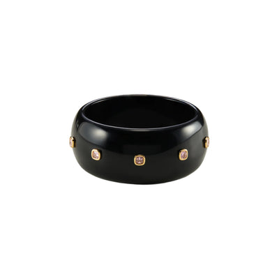 A glossy black ceramic bangle bracelet with five small gold-toned oval bezel-set stones, shown on a plain white background.