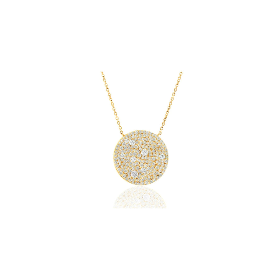 A gold necklace with a round pavé pendant set with clear stones, displayed on a clean white background with a soft reflection below.