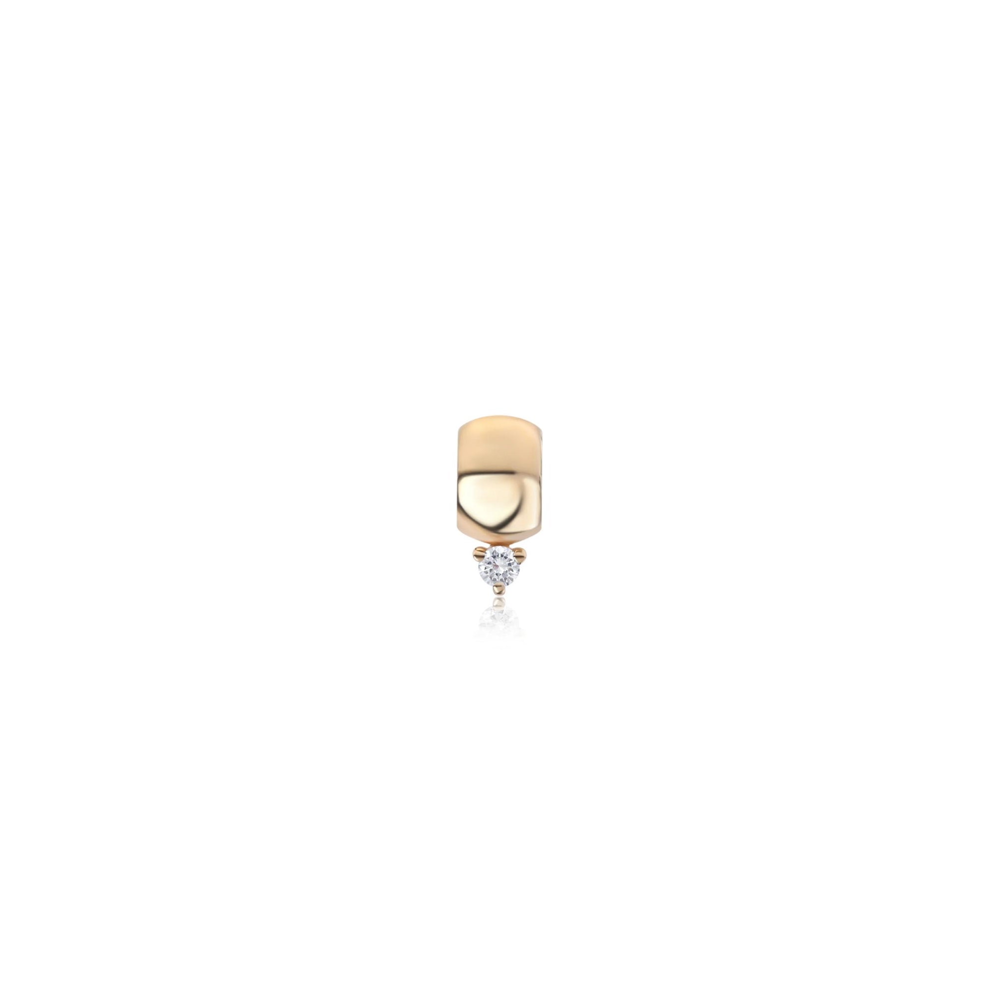 A small gold charm with a rounded rectangular top and a tiny round clear gemstone dangling below, centered on a plain white background.